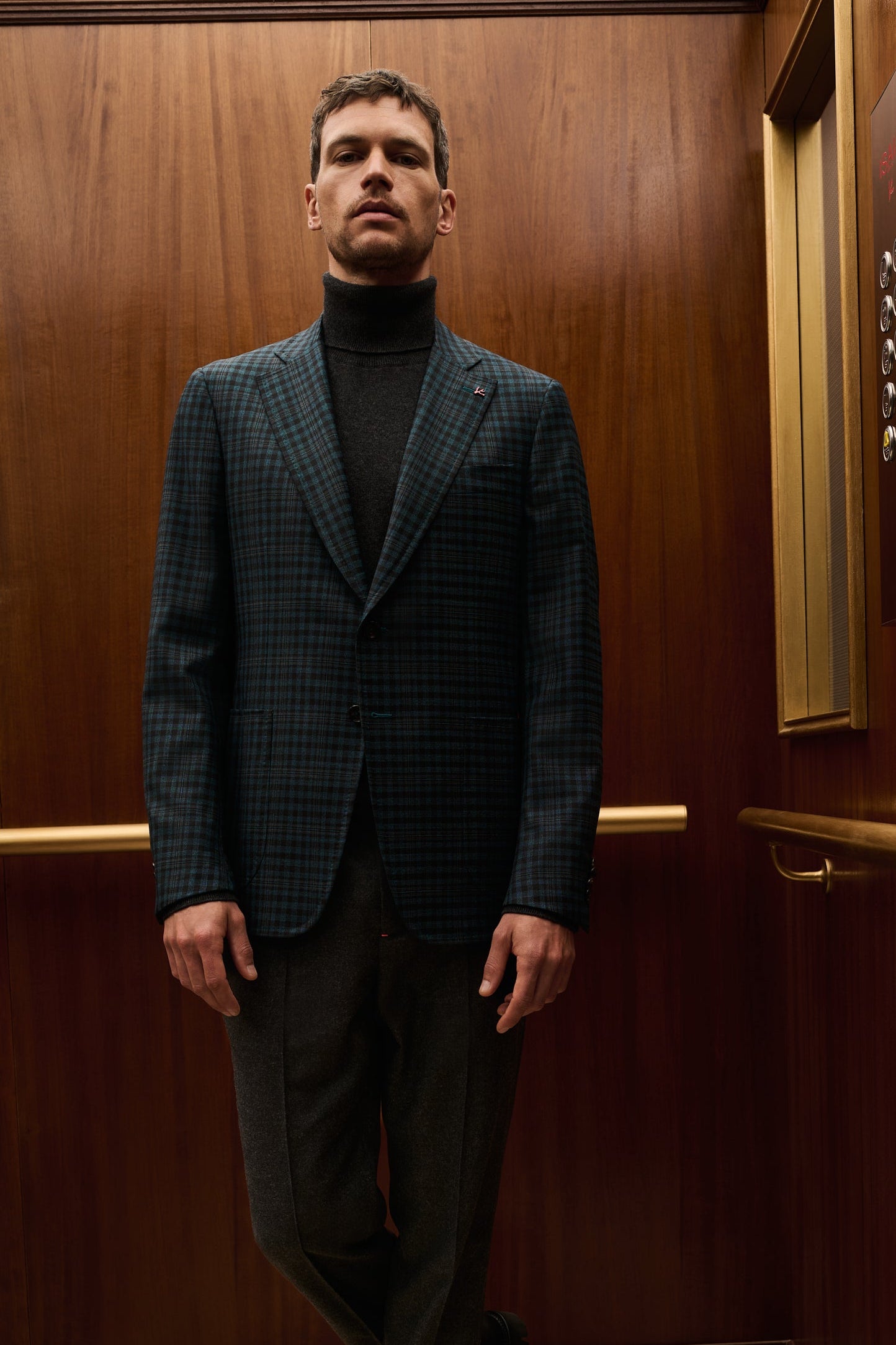 ISAIA Made to Measure: teal check jacket with black rollneck and dark trousers