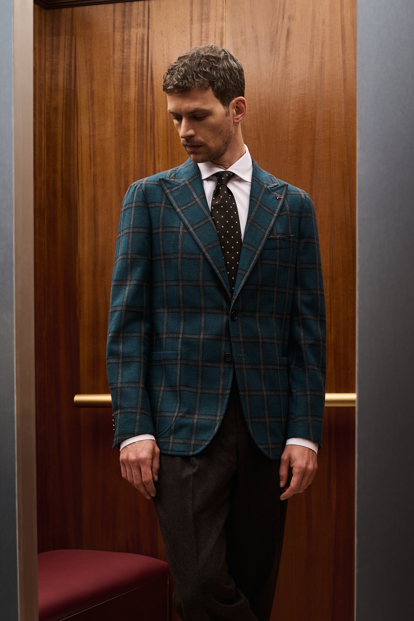 ISAIA Made to Measure: teal windowpane check jacket with dotted tie and brown trousers, legs crossed